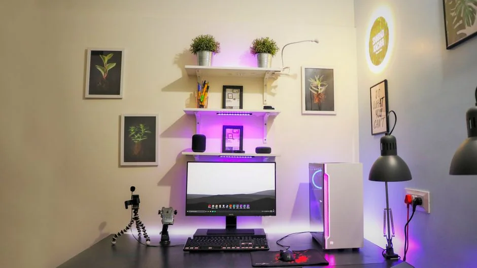 A top-down view of a minimalist workspace featuring a laptop and blank paper on a wooden table.